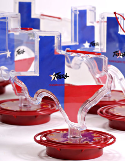 Item #108 – Texas Shaped 22 oz. easy fill plastic container. Guaranteed not to drip. Designed to feed ONLY hummingbirds. Red ABS Plastic base (non-metallic) Full ring perch with 8 feeding stations with metal hanger. Case Qty: 12